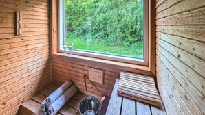 A wooden sauna room with a window, a bench, and a towel. - Beautiful home in Skjern with sauna (Skjern)