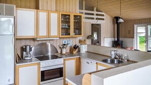 Una cocina moderna con armarios de madera, electrodomésticos de acero inoxidable y un horno empotrado.