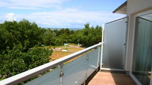 Un balcone con vista su un paesaggio verde e un edificio in lontananza.