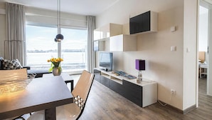 Una moderna camera d'hotel con angolo ristoro, TV e vista mare.