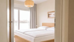 Una camera da letto con un letto di legno, un'ampia finestra e vista sull'esterno.