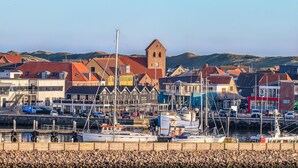 A coastal town with a marina, buildings with red roofs, and a prominent tower. - Lovely apartment in Hvide Sande (Hvide Sande)