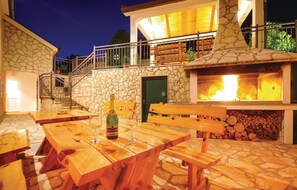 Enjoy dining and socializing in this outdoor patio area with an oven and comfortable seating.
