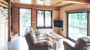 Eine Hütte mit einer Couch, einem Tisch und einem Fernseher.