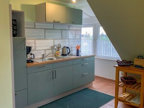 Kjøleskap, mikrobølgeovn, ovn og høy barnestol