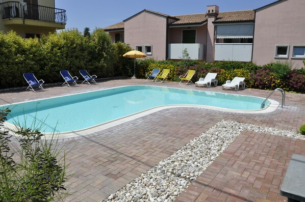 A swimming pool with lounge chairs and a patio area.