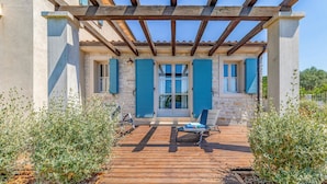 A covered outdoor area with a wooden deck, stone walls, and blue shutters. - Luxurious home in Fazana with sauna (Fazana)