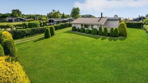A residential area with a well-maintained lawn, neatly trimmed hedges, and a house with a tiled roof. - Amazing home in Egernsund with WiFi (Egernsund)