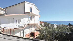 Ein zweigeschossiges Gebäude mit einem Balkon, einer Treppe und Blick auf das Meer.