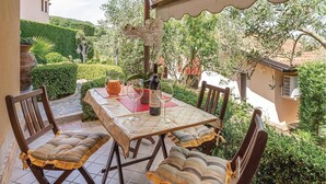 An outdoor patio with a table set for two, two chairs, a bottle of wine, and a pitcher of water. - Lovely home in Laurena Cilento SA (Laurena Cilento SA)