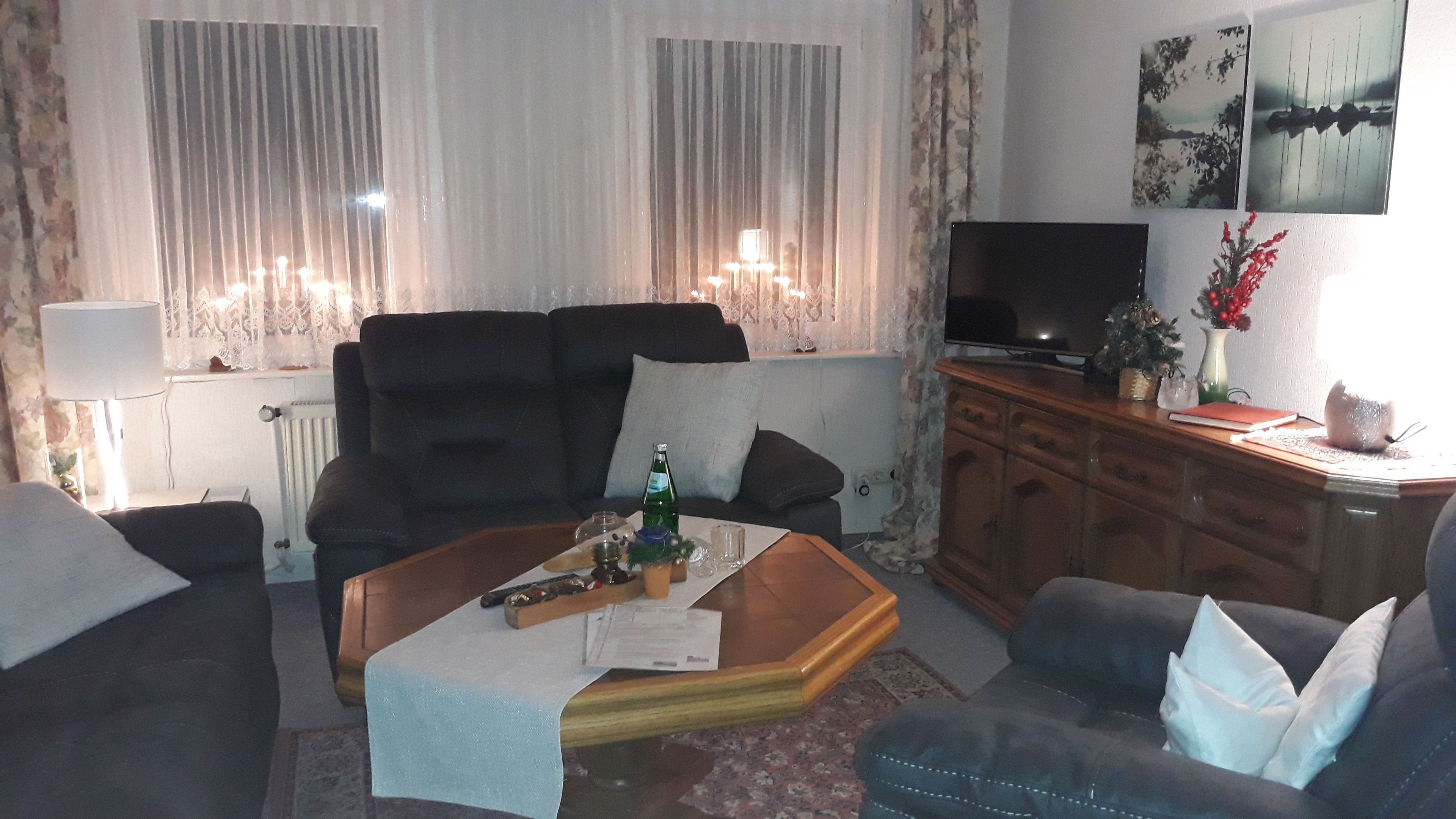 A living room with a sofa, coffee table, TV, and a cabinet.