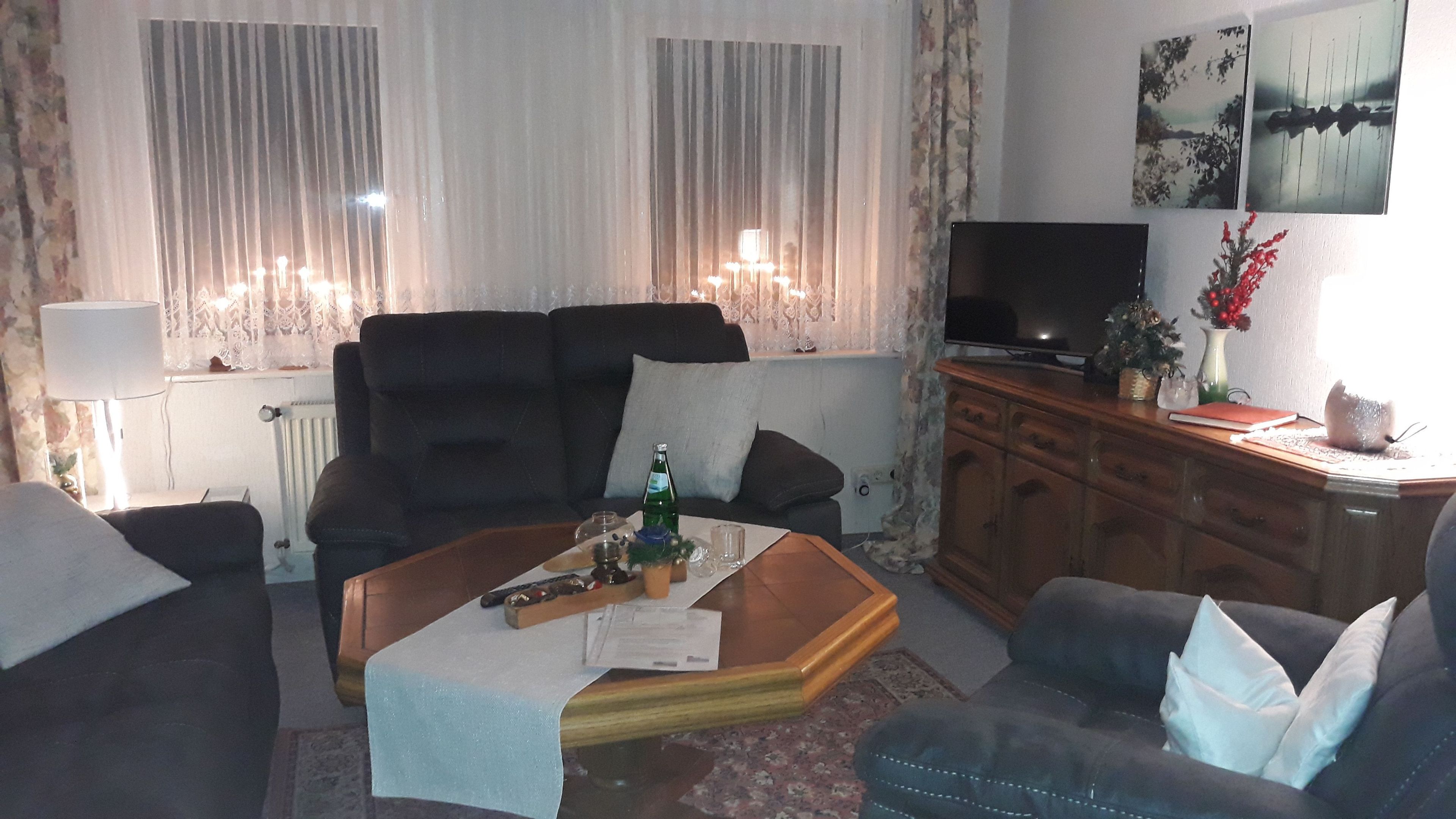 A living room with a sofa, coffee table, TV, and a cabinet.