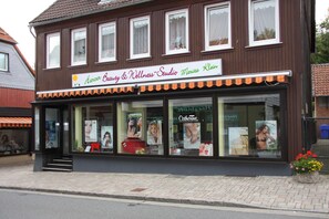 Ein zweistöckiges Gebäude mit einem Schild für das 'Harcener Beauty & Wellness-Studio Marita Klein'.
