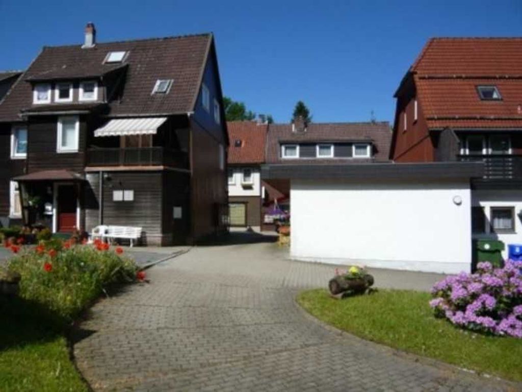 Uma área residencial com casas, um caminho pavimentado e um pequeno edifício branco.
