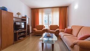 A living room with a sofa, two armchairs, a glass coffee table, and a TV on a wooden cabinet. - 3 bedroom gorgeous home in Duba (Duba)