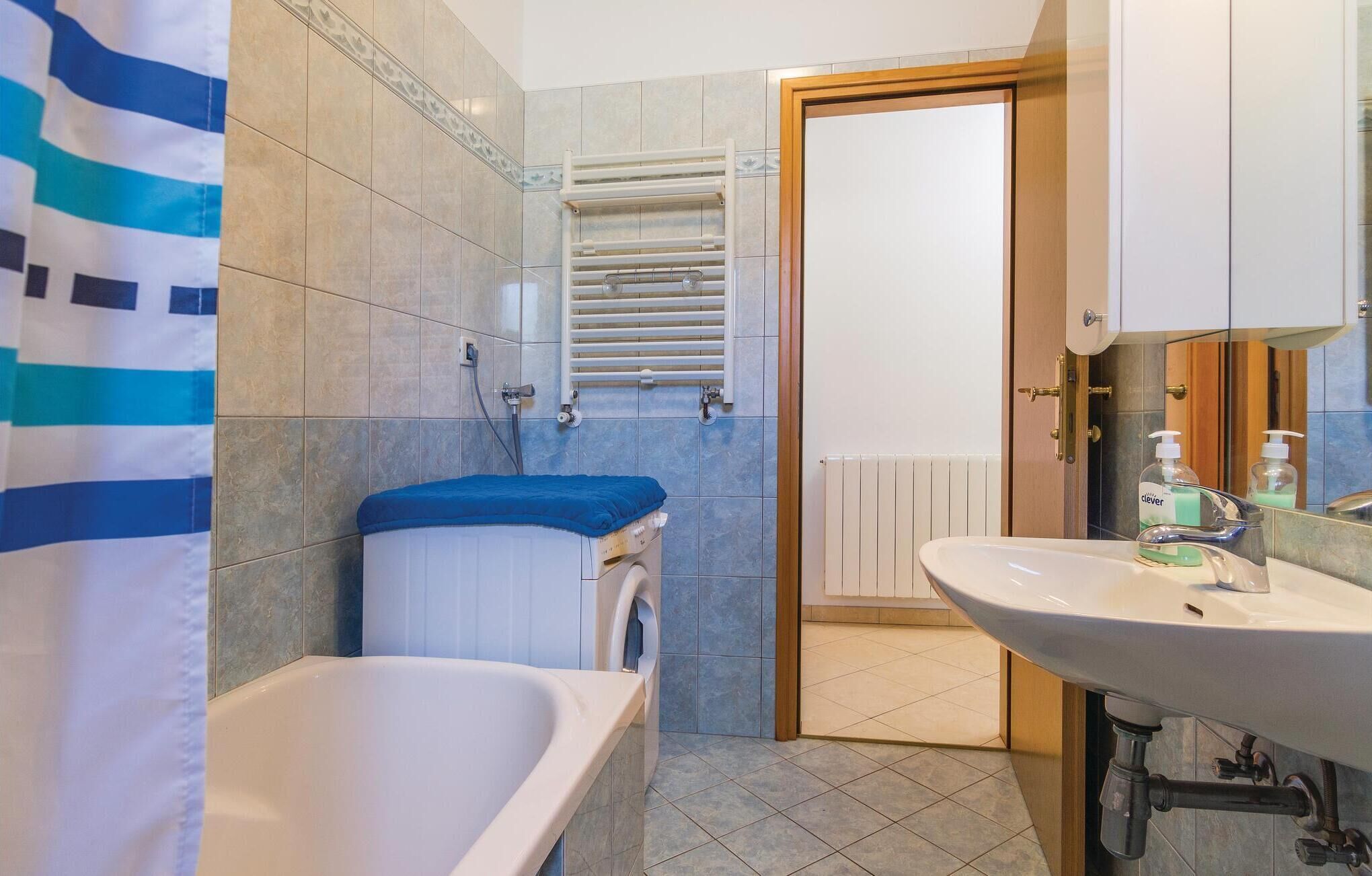 Un baño con bañera, ducha, inodoro y lavamanos.