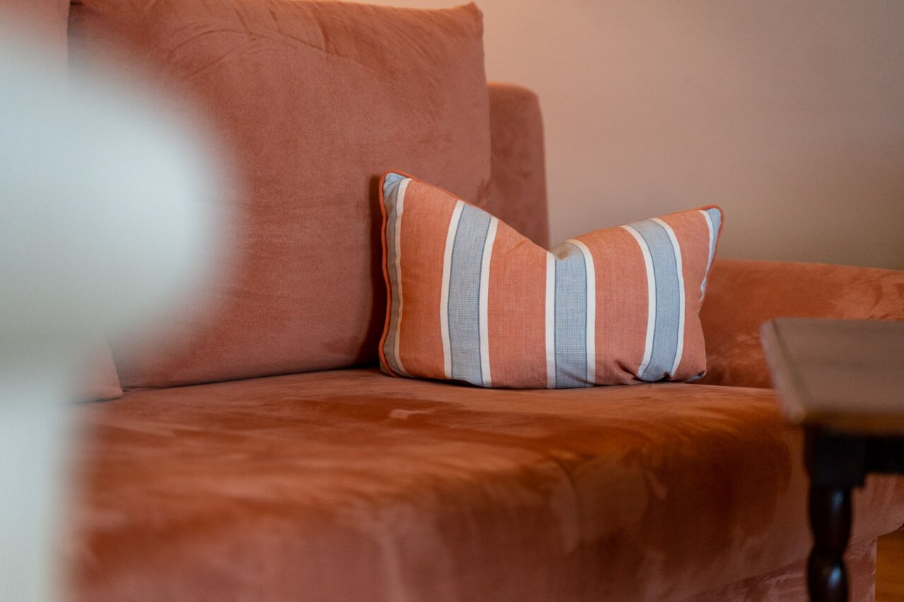 Un sofá con un cojín a rayas y una mesita en una habitación.