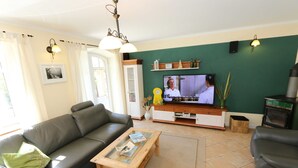 A living room with a sofa, coffee table, television, and a fireplace.