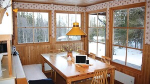 A wooden interior with a large dining table, chairs, a bench, and a hanging lamp. - Pet friendly home in Oviken with sauna (Oviken)