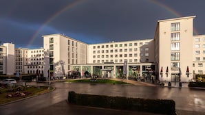 Un hotel con patio central, varios pisos y un estilo arquitectónico moderno.