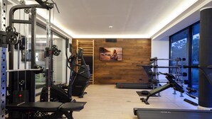 A gym with exercise equipment, a treadmill, and a large window.