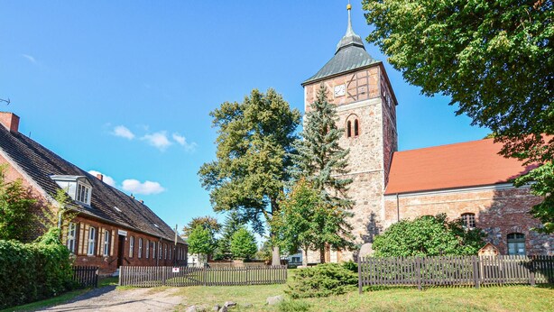 A historic building with a prominent tower, a red-roofed structure, and a traditional brick facade.