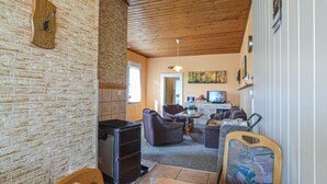 A cozy living room with a fireplace, comfortable seating, a television, and a painting on the wall.