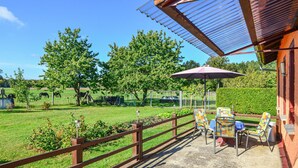 A patio with outdoor seating and a view of a fenced pasture with horses.