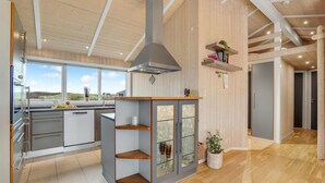 Une cuisine moderne dotée d’un îlot central, d’une grande fenêtre et offrant une vue sur l’extérieur.