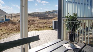 Un banc avec un pot de fleurs sur une terrasse carrelée.