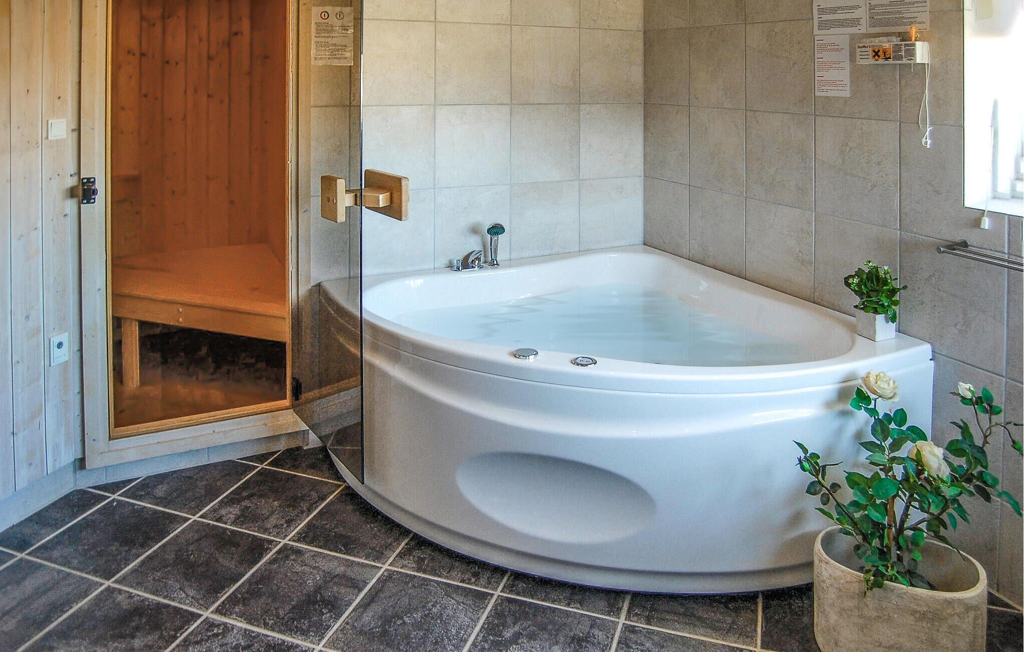 Une salle de bain moderne avec une baignoire sur pieds, une douche en verre et une plante en pot.