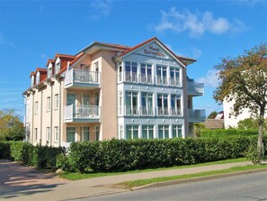 Ein mehrstöckiges Hotel mit Balkonen, einem roten Ziegeldach und einem Schild mit der Aufschrift "Haus Bernstamm".