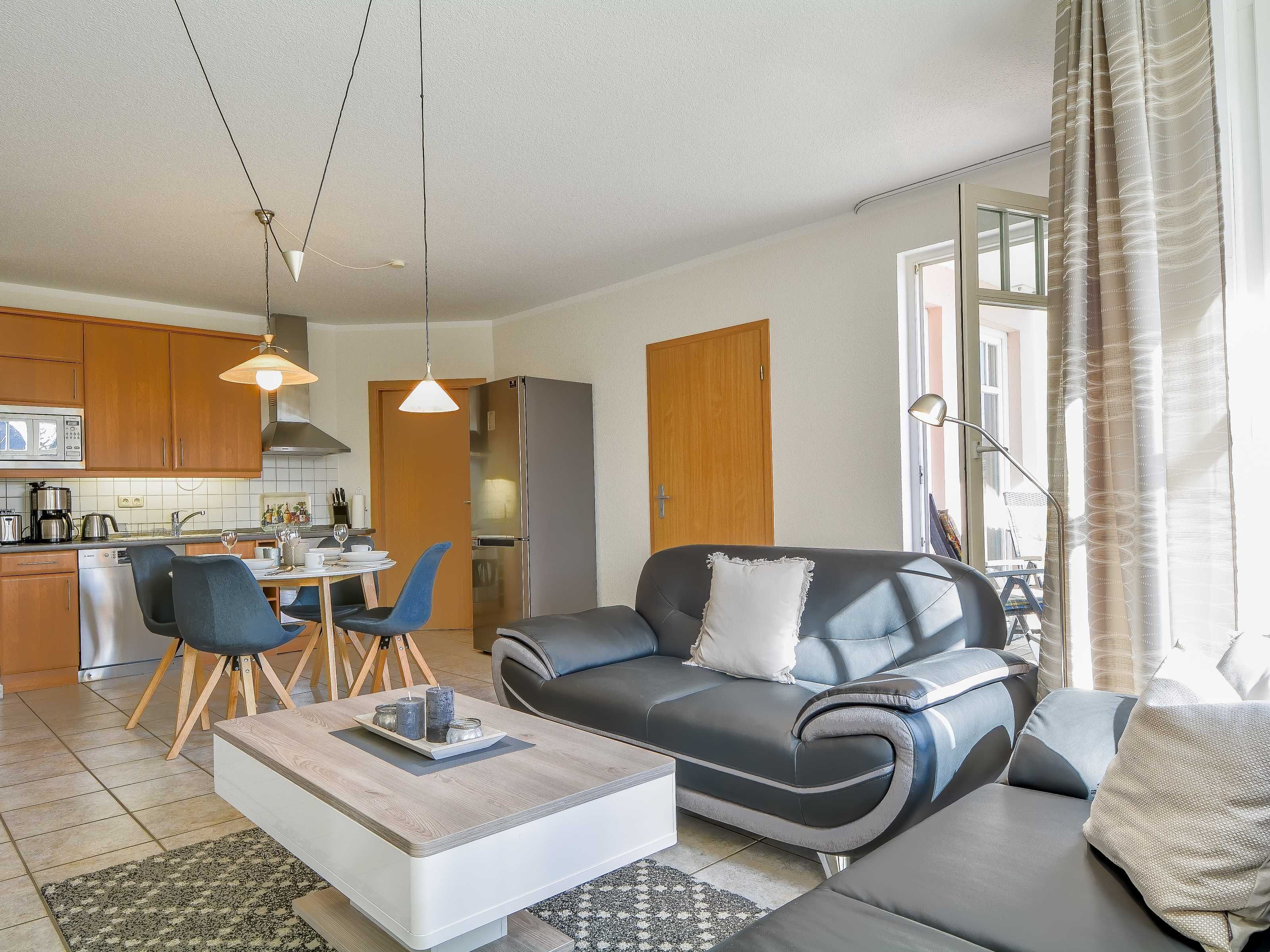 A modern living room with a sofa, coffee table, and dining area.
