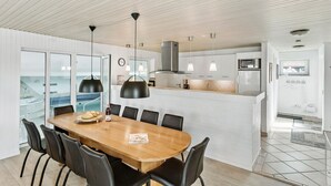 A modern kitchen with white cabinets, a central island, and black pendant lighting. - Awesome home in Væggerløse with sauna (Væggerløse)