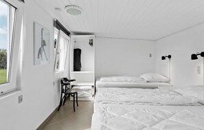 Un dormitorio minimalista con dos camas, un escritorio y una silla.