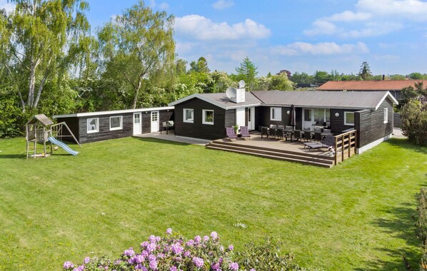 Una casa moderna de dos pisos con un patio y zona de estar al aire libre.