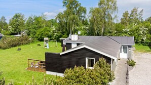 A modern house with a dark exterior, a sloped roof, and a small deck. - Awesome home in Væggerløse with sauna (Væggerløse)