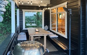 A cozy outdoor seating area with a table, benches, and a grill.