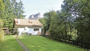 A house with a tiled roof, a small garden, and a wooden fence. - Gorgeous home in Vianden with WiFi (Vianden)