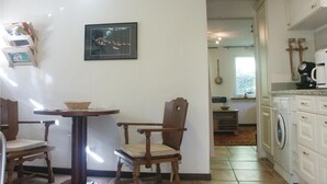 A small kitchen with a table and chairs, a washing machine, and a framed picture on the wall. - Gorgeous home in Vianden with WiFi (Vianden)