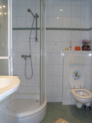 A bathroom with a shower, toilet, and sink. - Flower House - Flower House * (Rankwitz)