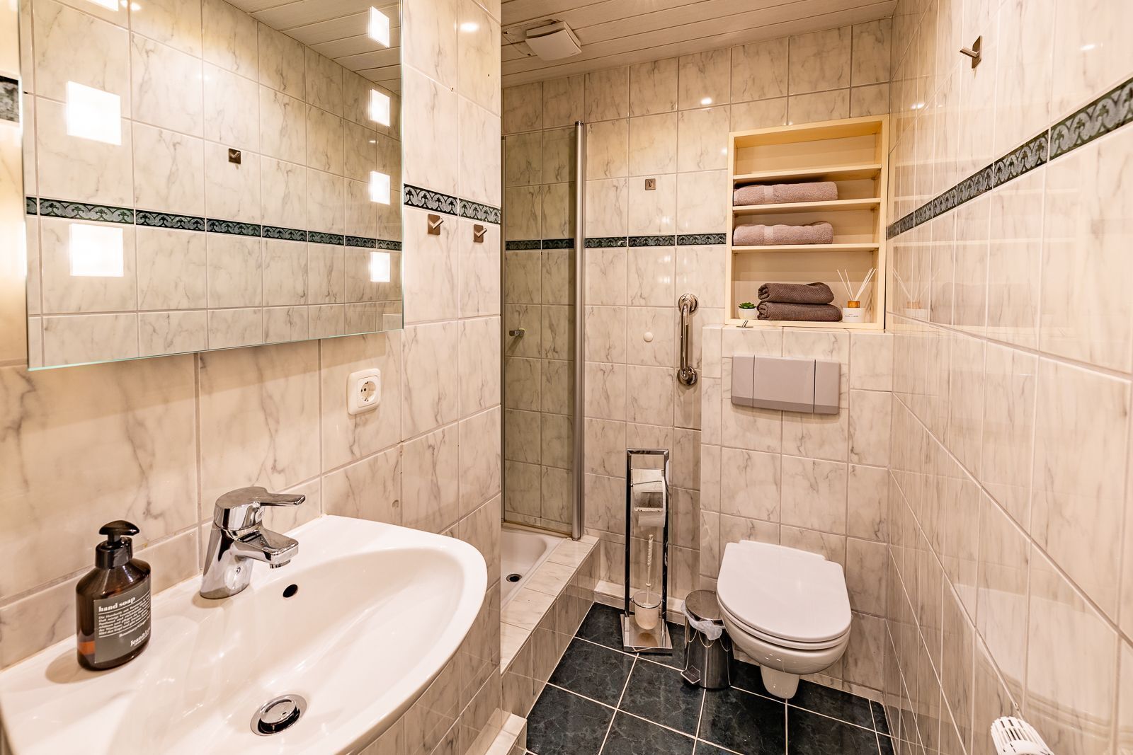 Une salle de bain moderne dotée d’un grand lavabo, de toilettes et d’un espace douche.