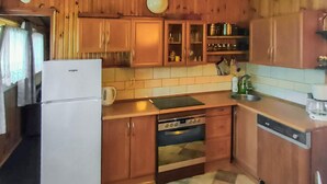 Una cocina con armarios de madera, un refrigerador, un horno y un lavavajillas.