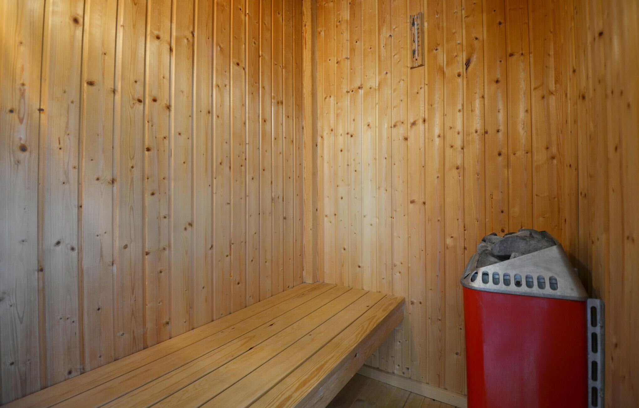 Un sauna avec des murs en bois et un banc.