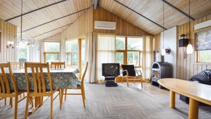 A cozy cabin interior with a dining area, a seating area with a fireplace, and a television. - Nice home in Hejls with WiFi (Hejls)