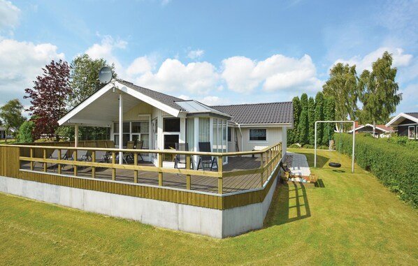 A modern house with a covered porch, a swing set, and a garden. - Nice home in Hejls with WiFi (Hejls)