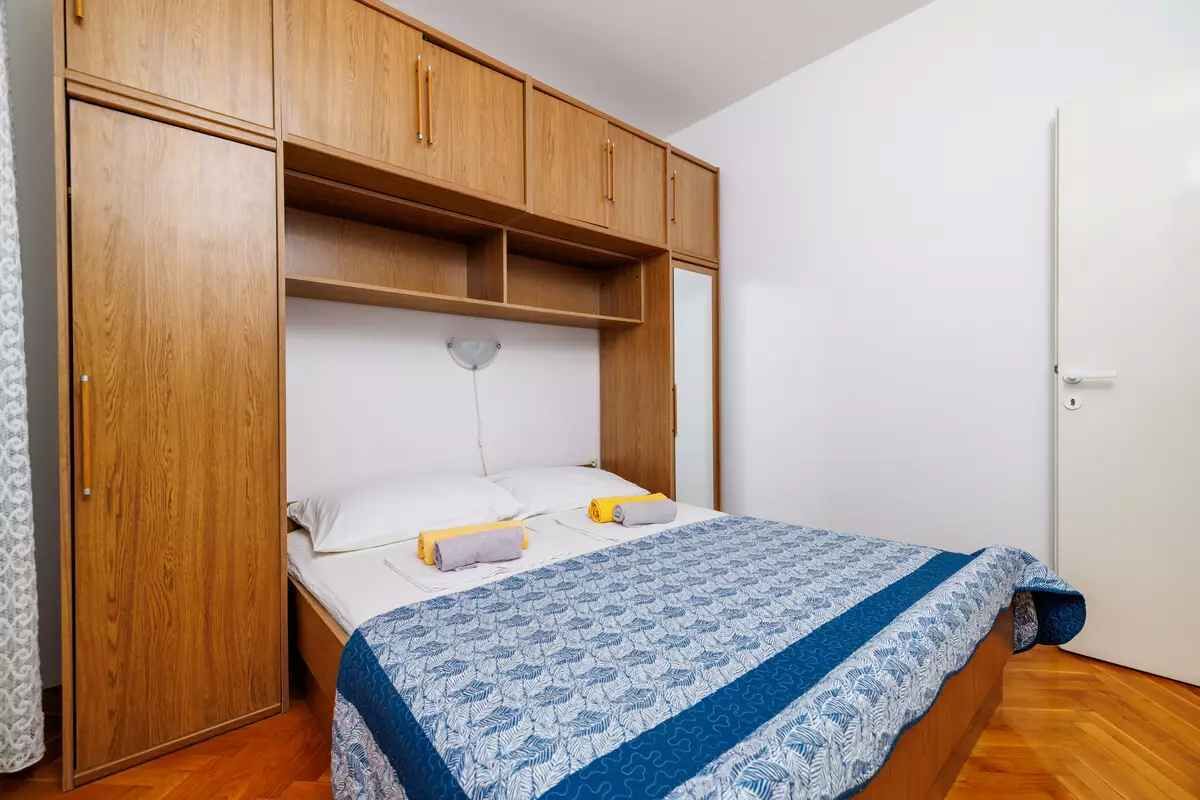 Une chambre à coucher avec un lit, une armoire en bois et une porte blanche.