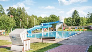 A swimming pool with a blue slide, a bench, and a lifeguard chair. - 2 bedroom nice home in Faßberg/Heidesee (Faßberg/Heidesee)
