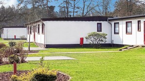 A row of white mobile homes with black roofs, each featuring a small garden area with a red mailbox and a young tree. - 2 bedroom nice home in Faßberg/Heidesee (Faßberg/Heidesee)