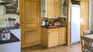 A kitchen with wooden cabinets, a stove, and various kitchen items.